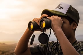 a man using binoculars to help him find the best explainer video company