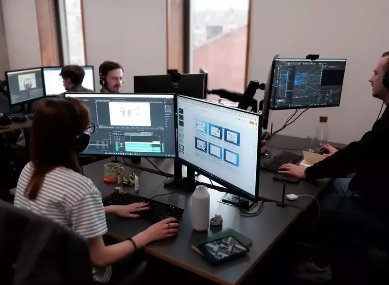 4 motion graphic designers working on animated video productions at their computers